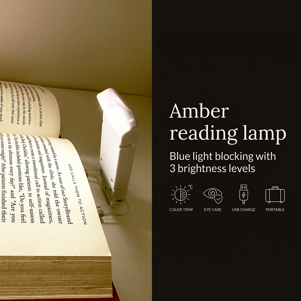 Close-up view of the minimalist clip-on reading light attached to a paperback book at night, emitting an eye-protective amber light with clean overlay text reading Amber reading lamp.