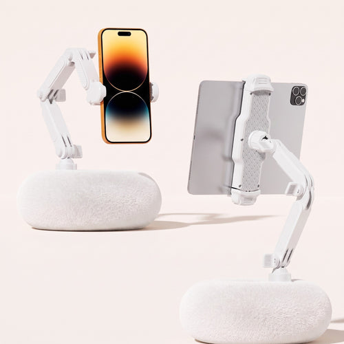 A side-by-side product comparison showing two By1994 Ivory White plush pillow stands, one holding a mobile phone vertically (Standard size) and the other supporting a large tablet horizontally (Large size) to demonstrate dual-size utility.