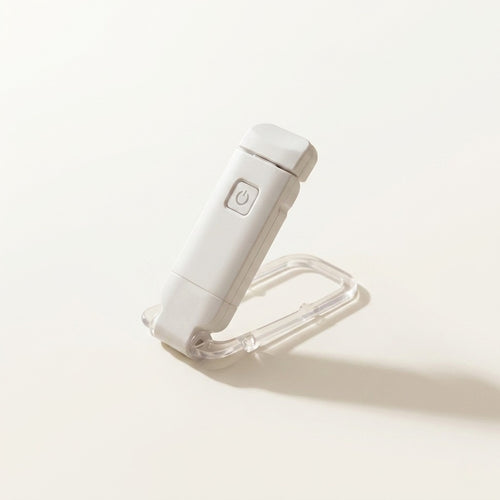 A crisp lifestyle hero image showcasing a white portable LED book light arranged beautifully on a clean canvas cream background.